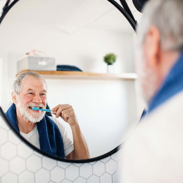mature gentleman brushing his teeth